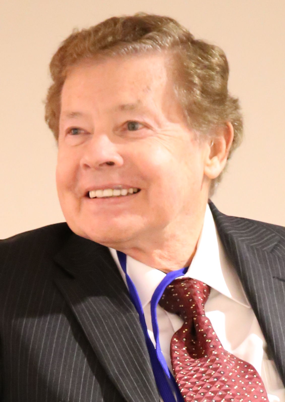 Lou Wagner was captured in the smiley face and looking at the front side wearing coat shit and tie 