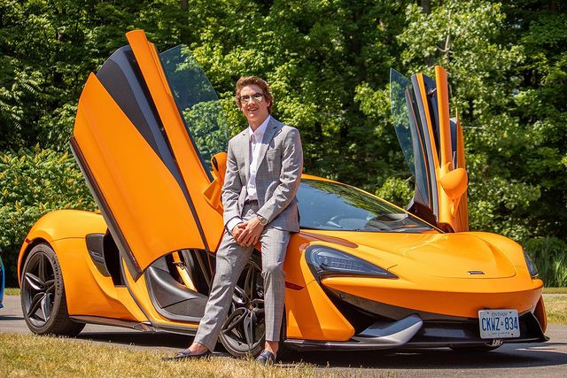 Picture of Isaac Kragten posing for a photoshoot wearing grey color blazer and glasses