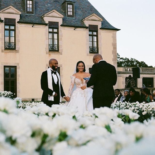Steph Lecor clicking photo with her husband with a white bridal gown on her wedding