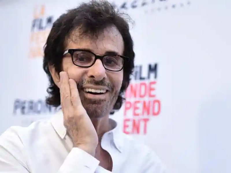 George Chakiris in his old age posing for the picture looking with one hand on his cheek and wearing spectacle 