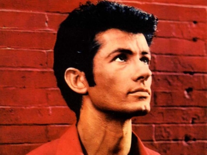 George Chakiris in his young age posing for the picture looking above 