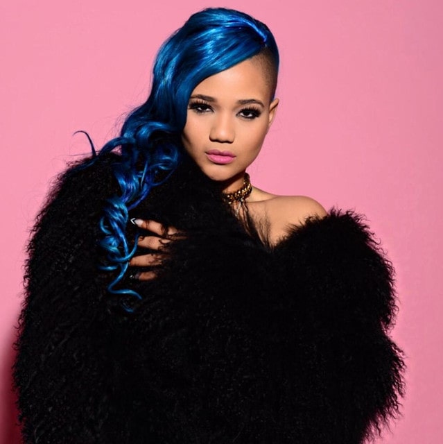 Steph Lecor posing for the photo wearing black sweater type dress and with a sparkling blue long hair