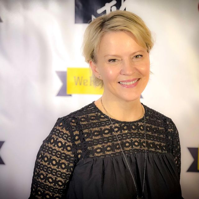 Picture of Marguerite MacIntyre posing for a photoshoot wearing black color dress