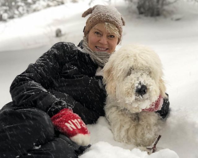Picture of Marguerite MacIntyre with her pet wearing gloves and jacket