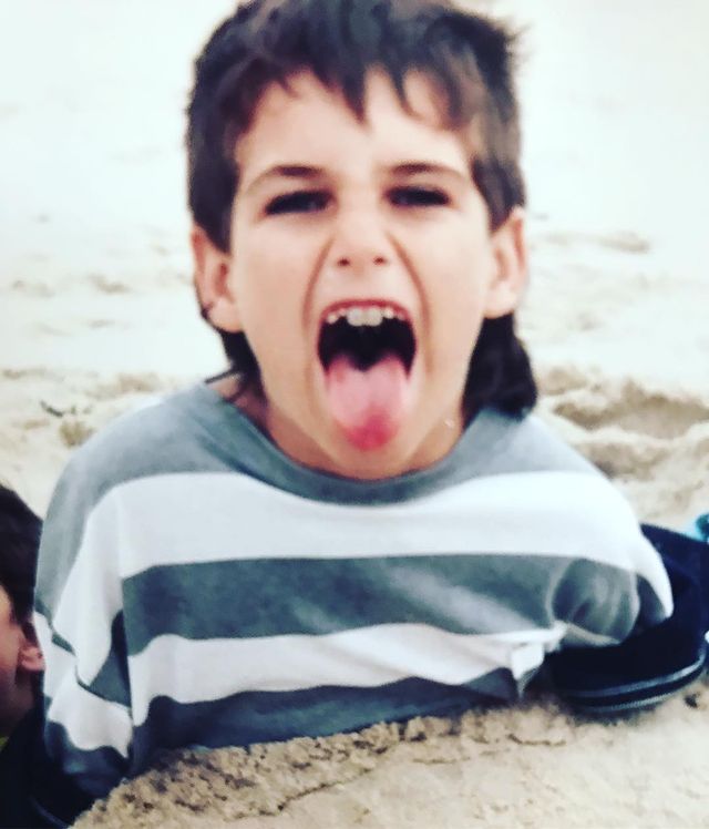 Childhood picture of Adam Pally while playing with sand.