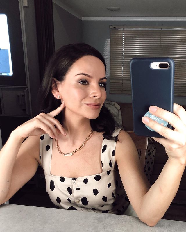 Picture of Brooke Palsson posing for a photoshoot with her phone wearing black and white gown