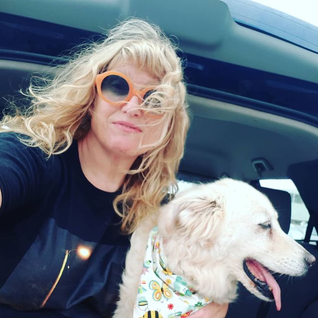 Picture of Jackie Torrens with her pet posing for a photoshoot wearing black color dress