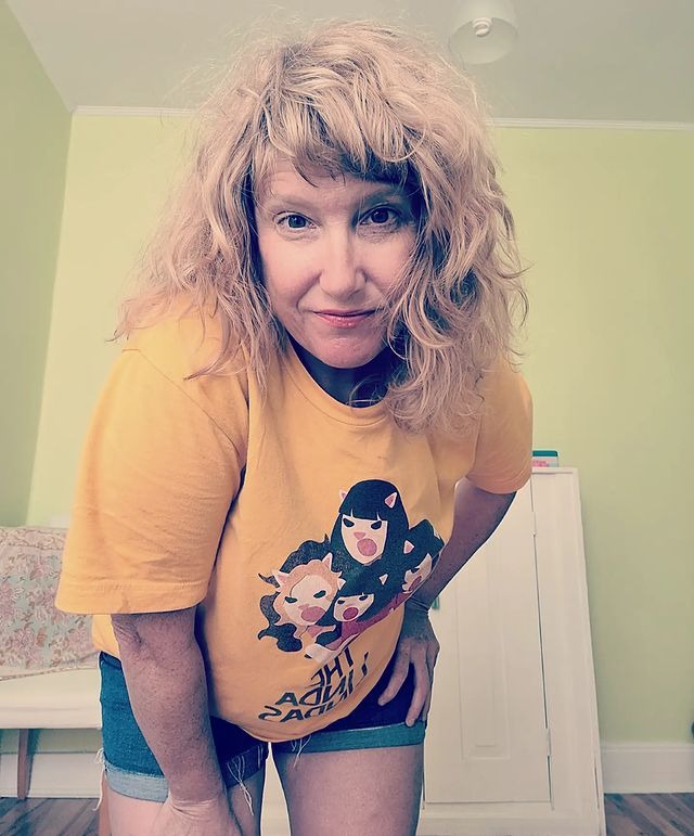 Picture of Jackie Torrens posing for a photoshoot wearing yellow color t shirt and short jeans