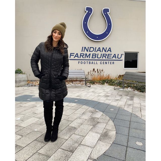Taylor Tannebaum posing in front of the Indiana farm bureau football center WTHR