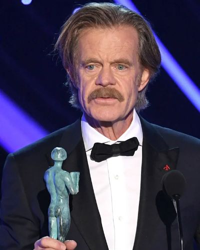 William H Macy holding an award. 